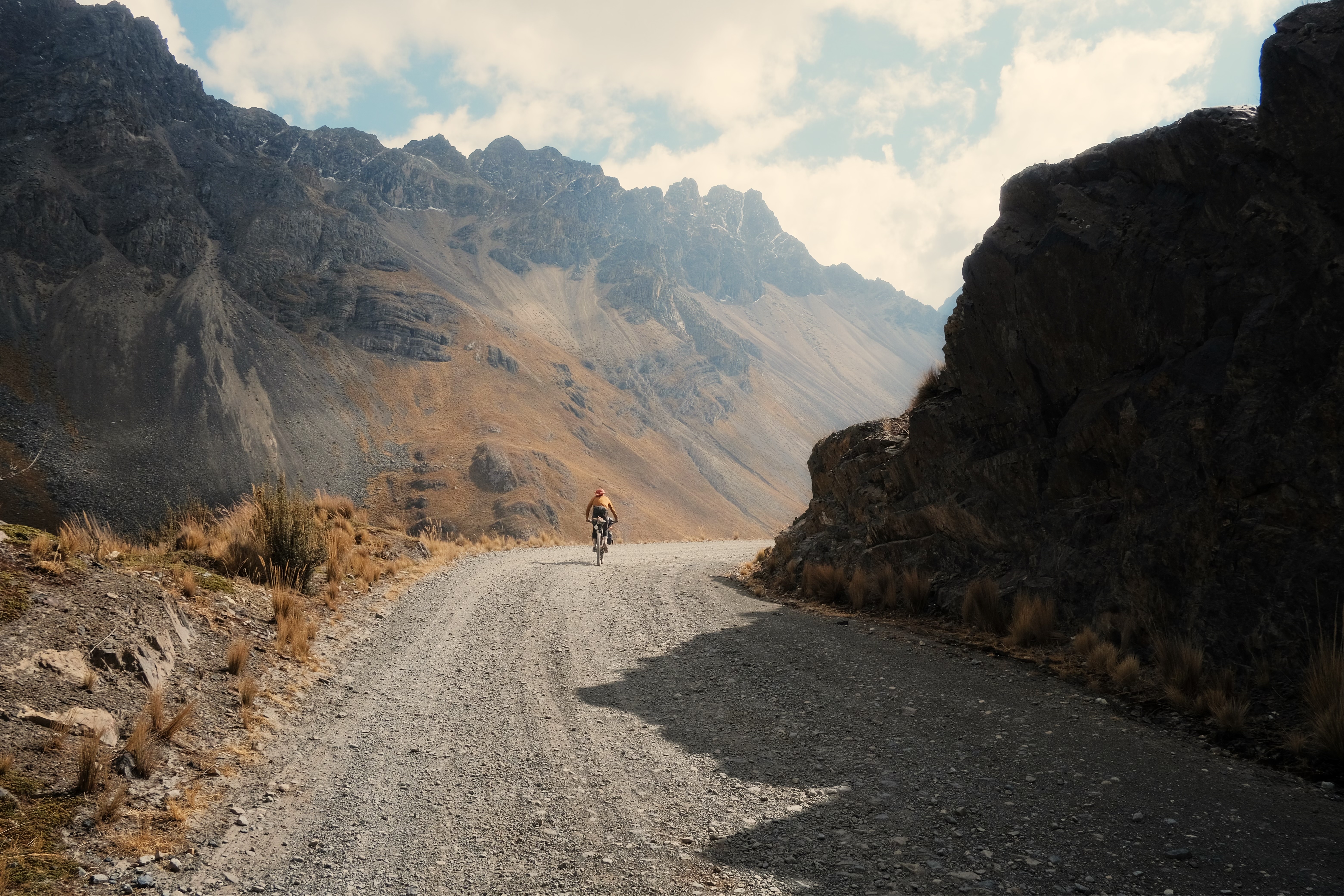 Cyclist disappearing into the mountains